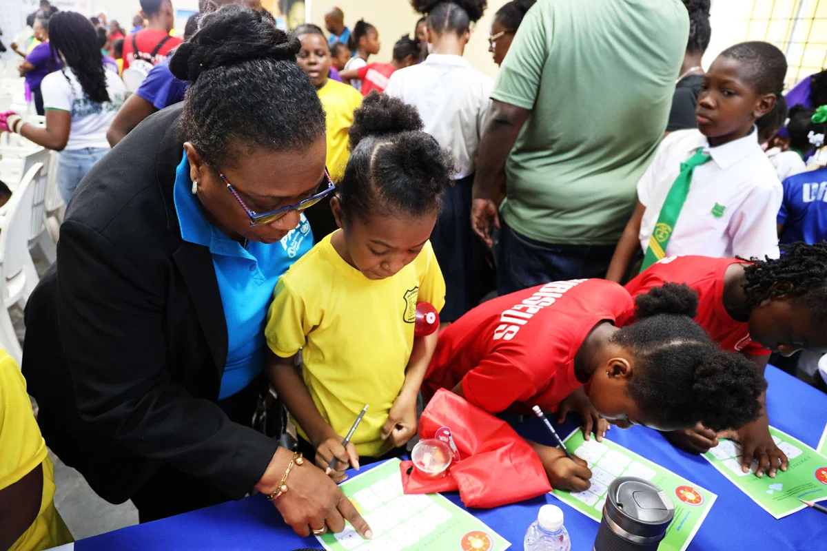 Photo Credit: PAHO/WHO/Thelca White - Dr. Audrey Morris helps a student with a WNTD activity at the PAHO booth